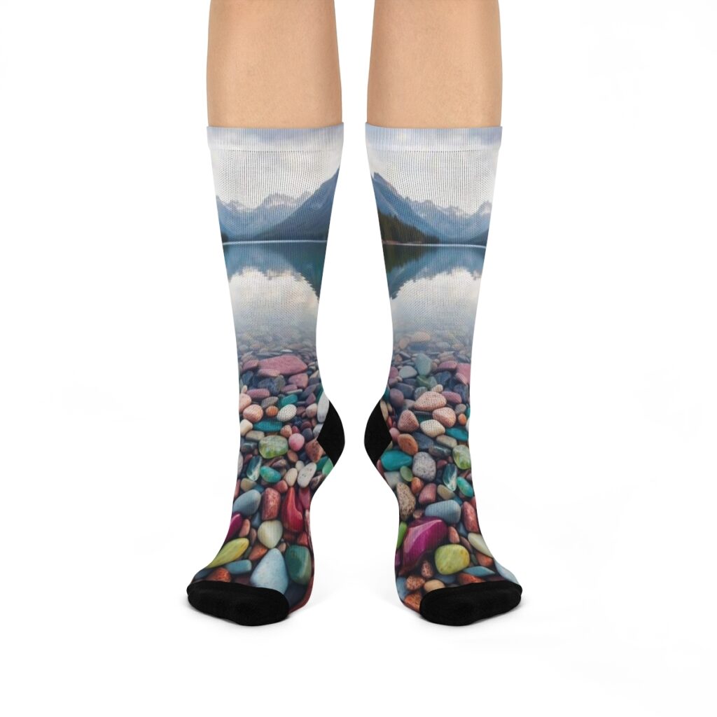 Some of the best hiking socks showing a picture of colorful rocks on a clear lake with mountains in the back.